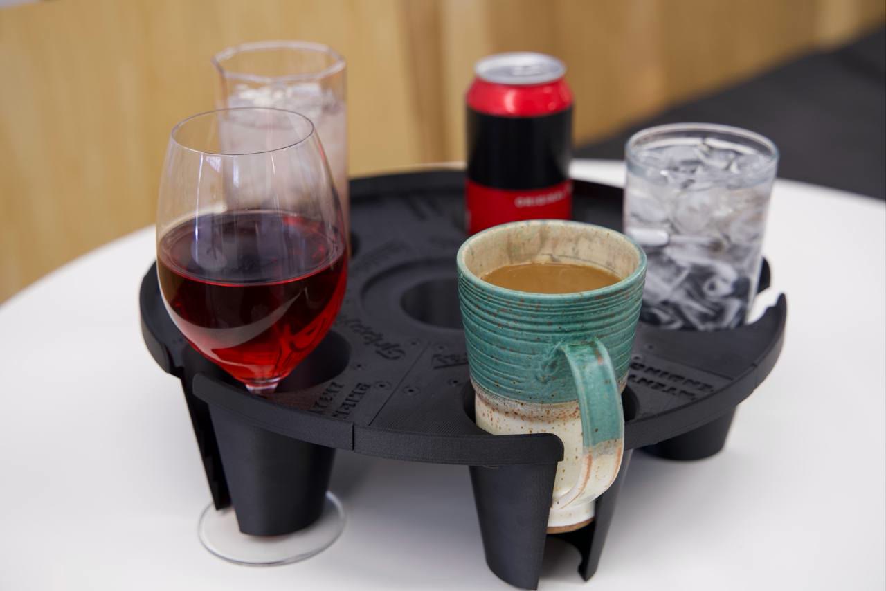 Front view of the final round GrippyTray loaded with a coffee mug, wine glass, soft drinks, and a can